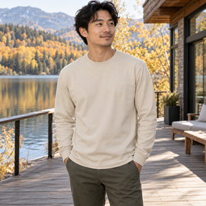 American Apparel 1304 in Sand, an East Asian man aged 30 at an elegant lakeside wooden deck with a modern chalet and bright autumn light; illustrative lifestyle mockup