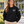 Adult Cedarcrest Elementary teacher in black CSW 24/7 L00540, white chest crest and horizontal STAFF on upper sleeve
