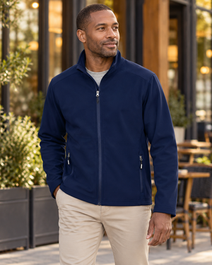 Model wearing the CORE365 88184 men's soft shell jacket outside a café - Classic Navy