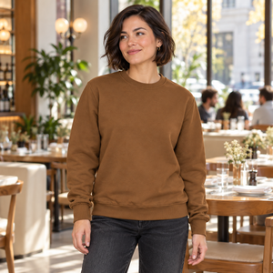 Woman wearing the CSW 24/7 L00540 Caramel crewneck sweatshirt in a bright restaurant