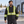 Model wearing the CX2 Kenworth 5-in-1 hi-vis coat's quilted inner jacket in an industrial courtyard - Black