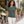 Woman wearing the M&O 3540 Heather Green crewneck T-shirt beside a flower shop courtyard