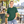 Next Level 3600 Unisex Cotton Tee in Royal Pine — woman at a bright riverside espresso kiosk