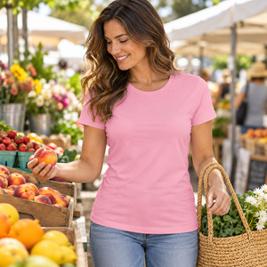 Next Level 3900 Women's Cotton Tee in Light Pink — woman selecting fresh fruit at a stylish open-air market