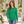 Next Level 6211 Unisex CVC Long Sleeve Tee in Kelly Green — woman walking through an arboretum with pale stone architecture