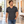 Next Level 6240 Unisex CVC V-Neck Tee in Charcoal — man walking through a warm contemporary gallery lobby