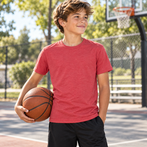 Next Level 6310 Youth Triblend Tee in Vintage Red — 12-year-old boy at an outdoor community basketball court, ball at his side