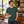 Next Level 6410 Unisex Sueded Tee in Heather Forest Green — man at a quiet premium listening bar in daylight