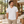 Next Level 6440 Unisex Sueded V-Neck Tee in White — man in a contemporary hotel atrium with timber and linen furnishings