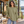 Next Level 7211 Unisex Heavyweight Long Sleeve Tee in Light Olive — woman at a wooded Nordic-style cabin terrace