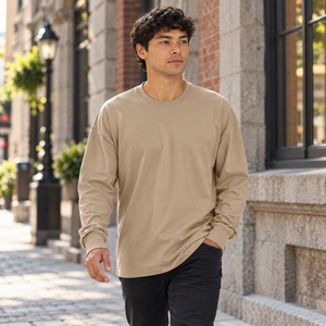 Next Level 7211 Unisex Heavyweight Long Sleeve Tee in Tan — man walking past warm brick architecture in Old Montreal