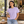 Next Level 7610 Women's Heavyweight Boxy Tee in Lavender — woman holding a design magazine at a chic independent cafe