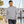 Next Level 9000 Unisex Laguna Raglan Crewneck Sweatshirt in Heather Grey — man walking along a quiet marina on a cool morning