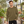 Next Level 9002 Unisex Malibu Crewneck Sweatshirt in Heather Military Green — man at a contemporary botanical greenhouse on a cool day