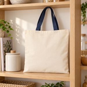Q-Tees QTB6000 natural cotton tote with navy handles on an oak pantry shelf